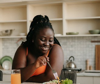 Woman smiling while eating lunch at home
