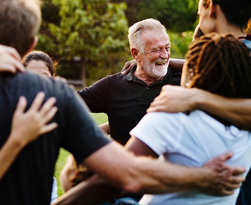 Happy Houston patient enjoying friends with new dentures