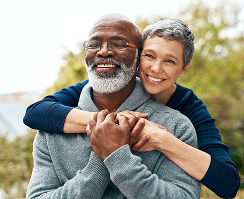 Couple smiling after receiving dentures in Houston