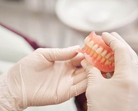 Dentist holding full dentures