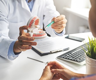 Patient pointing to model of teeth