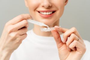 Woman using an at-home teeth whitening kit from her dentist