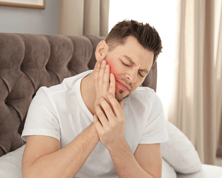 Man holding jaw in pain